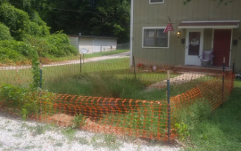 Photo of house with a sink hole blocked off with orange fencing