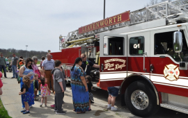 Community members lining up to see inside a Fire truck at a local park