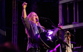 Photo of singer Melissa Etheridge on stage playing guitar