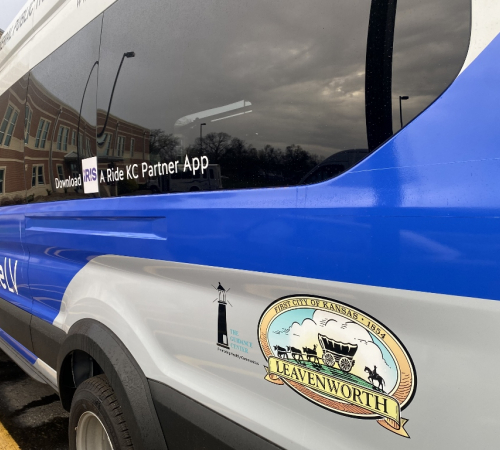 Photo of Ford Transit 350 van in blue and white with "RideLV" logo, City of Leavenworth logo and The Guidance Center logo