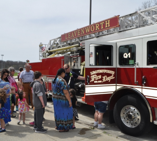 Community members lining up to see inside a Fire truck at a local park