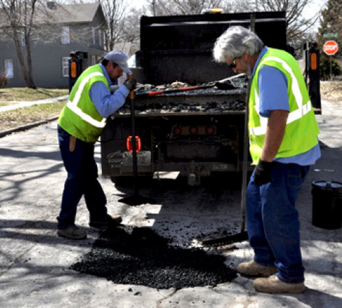 City street workers fix pot holes in March 2019