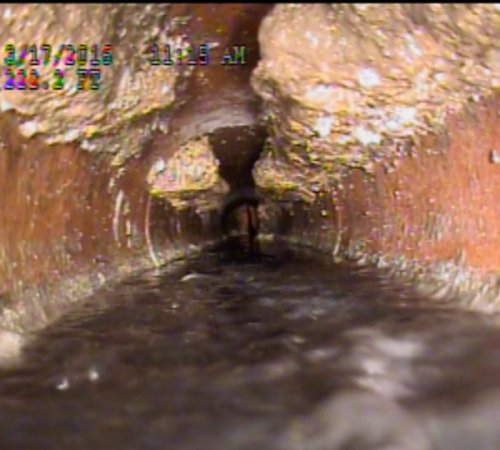 City sewer blockage - white spots along a pipe are a buildup as a result of fat or grease poured down the drain.