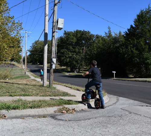 Child lifts bike over curb without ADA ramp