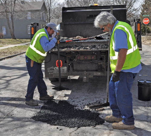 City workers do street patching repair along Ottawa Street.