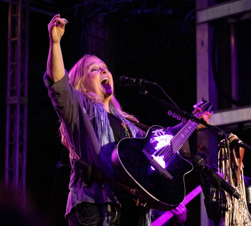 Photo of singer Melissa Etheridge on stage playing guitar