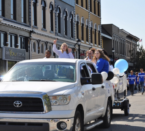 parade photo of girl riding in vehicle