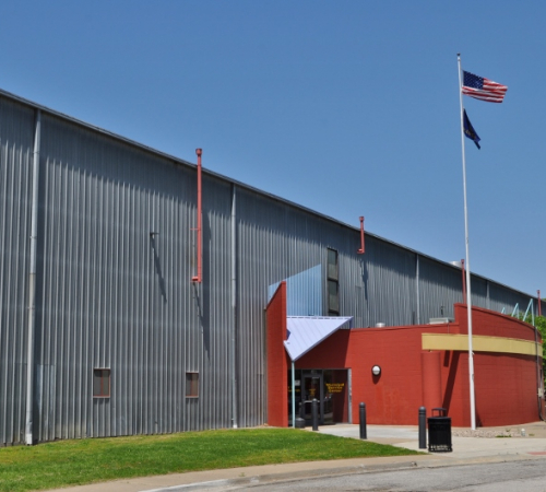 photo of large building with American and Kansas flags out front