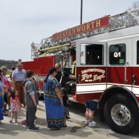 Community members lining up to see inside a Fire truck at a local park