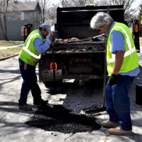 City street workers fix pot holes in March 2019