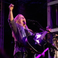 Photo of singer Melissa Etheridge on stage playing guitar