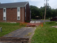 Brick building with a sink hole and orange fencing