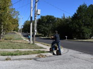 boy struggles to lift bike over curb with no ramps