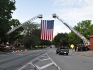Fire trucks of Fort Leavenworth and Leavenworth Fire Departments hang giant American flag for American military funeral