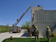 Firefighters climbing ladder and building