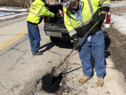 City workers patch street along Shrine Park Road in 2019.