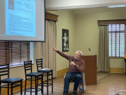 Man in wheelchair pointing to a presentation