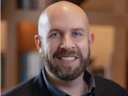 Dr. Jason Bosch photo, man looking at camera smiling wearing a button down blue shirt and blazer