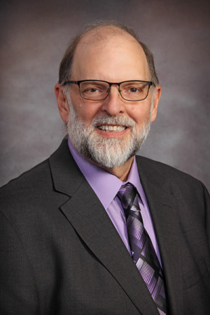 Photo of man with gray hair, beard, tie and sport coat