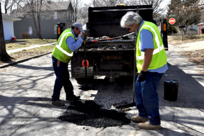 City street workers fix pot holes in March 2019