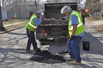 City workers do street patching repair along Ottawa Street.