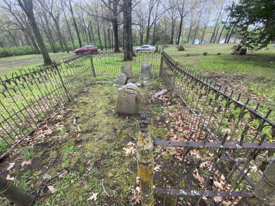 set of grave stones in a field surrounded by a fence