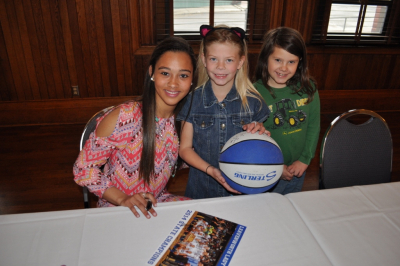 Girls smiling with signed basketball