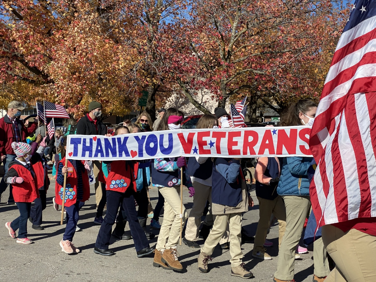 Children carry banner in Veterans Day parade that reads, "Thank You Veterans"