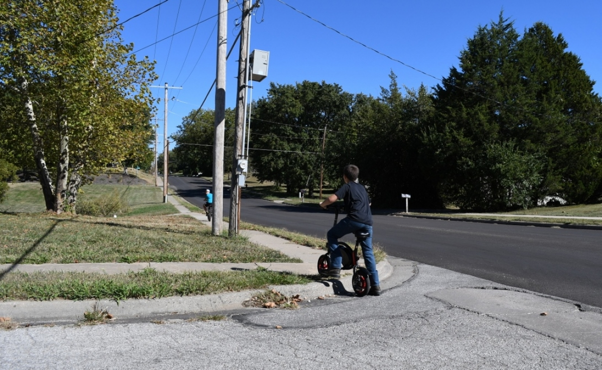 Child lifts bike over curb without ADA ramp