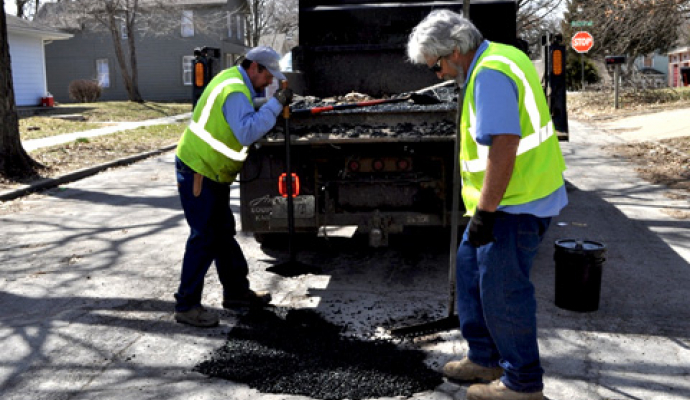 City street workers fix pot holes in March 2019