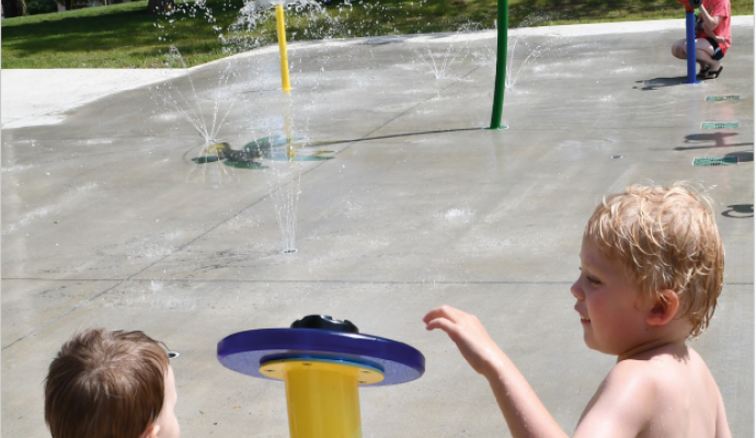 Photo of the front page of the newsletter shows a photo of two young boys pushing the button at the Leavenworth Splash pad